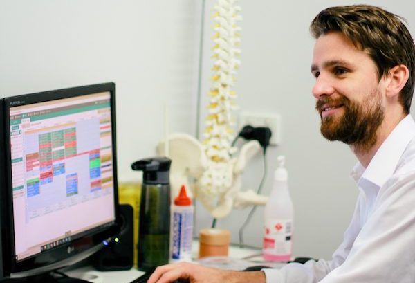 physio at desk with spine